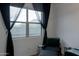 Bright bedroom with large window with sheer curtains and a cushioned lounge chair with side tables at 34395 N Cherrystone Dr, San Tan Valley, AZ 85144