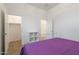 Bedroom features a purple comforter on bed with open doors to the closet and hallway at 34395 N Cherrystone Dr, San Tan Valley, AZ 85144