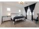 Comfortable bedroom with a black metal bed frame, soft carpet, and bright natural light at 34395 N Cherrystone Dr, San Tan Valley, AZ 85144