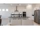 A lovely kitchen offers white cabinets, black countertops, stainless steel appliances, and a central island at 34395 N Cherrystone Dr, San Tan Valley, AZ 85144