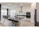 Bright, eat-in kitchen with white cabinets, black countertops, an island with seating, and stainless steel appliances at 34395 N Cherrystone Dr, San Tan Valley, AZ 85144