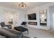 Spacious living room boasts fireplace, large TV, modern lighting and comfortable furniture at 34395 N Cherrystone Dr, San Tan Valley, AZ 85144