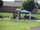 Community playground area with shade, slides and a bench on a large lawn at 34395 N Cherrystone Dr, San Tan Valley, AZ 85144