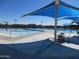 Community pool area with blue sunshades, lounge chairs and splash pad on a sunny day at 34395 N Cherrystone Dr, San Tan Valley, AZ 85144