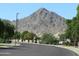 Street view lined with mature trees, with a mountain visible in the background at 34395 N Cherrystone Dr, San Tan Valley, AZ 85144