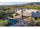 Aerial view of a custom home showcasing its pool, outdoor fireplace, and manicured landscaping at 37870 N 98Th Pl, Scottsdale, AZ 85262