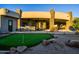 Expansive backyard featuring a putting green, covered patio, and stone accents on a modern home at 37870 N 98Th Pl, Scottsdale, AZ 85262