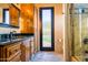Bathroom with wood cabinets, granite countertop, framed mirror, and a door to the outside at 37870 N 98Th Pl, Scottsdale, AZ 85262