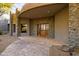 Inviting entrance featuring a stone accent wall, custom wooden doors, and covered porch, blending rustic and modern design at 37870 N 98Th Pl, Scottsdale, AZ 85262