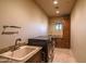 Clean laundry room with modern appliances, granite counters, sink and storage cabinet at 37870 N 98Th Pl, Scottsdale, AZ 85262