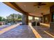 Extended outdoor living space with a stone patio, seating, and pool area at 37870 N 98Th Pl, Scottsdale, AZ 85262