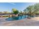Resort-style pool with waterfall feature surrounded by stone patio and lush landscaping at 37870 N 98Th Pl, Scottsdale, AZ 85262