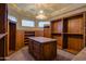 Spacious walk-in closet with custom cabinetry, an island, and elegant chandelier lighting at 37870 N 98Th Pl, Scottsdale, AZ 85262