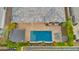 An aerial view of a backyard with a sparkling pool, outdoor kitchen, patio seating, desert plants, and green grass at 3882 E Andalusia Ave, Gilbert, AZ 85298