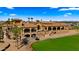 Grand clubhouse and golf cart parking with manicured lawns and palm trees, providing a luxurious experience at 3882 E Andalusia Ave, Gilbert, AZ 85298