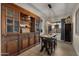 Elegant dining area with a large wooden hutch, a modern chandelier, and tile floors at 3882 E Andalusia Ave, Gilbert, AZ 85298