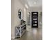 Stylish foyer featuring wood-look tile floors, a decorative mirror, and a modern console table at 3882 E Andalusia Ave, Gilbert, AZ 85298