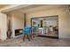 Patio with a fireplace and a view of the kitchen with white cabinets, stainless steel appliances, and island seating at 3882 E Andalusia Ave, Gilbert, AZ 85298