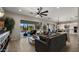 Bright living room with a ceiling fan, view of the backyard, and open floor plan flows into the kitchen at 3882 E Andalusia Ave, Gilbert, AZ 85298