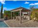 This outdoor kitchen is perfect for entertaining with a grill, bar seating, a tv, and a pergola at 3882 E Andalusia Ave, Gilbert, AZ 85298