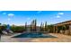 A backyard pool features a waterfall feature, desert landscaping, lounge chairs, and an outdoor seating area with a pergola at 3882 E Andalusia Ave, Gilbert, AZ 85298