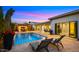 A luxurious backyard pool with a covered patio, outdoor seating, and manicured landscaping offers a perfect retreat at 3882 E Andalusia Ave, Gilbert, AZ 85298