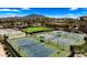 Aerial view of pristine tennis courts surrounded by lush landscaping, nestled in a vibrant community with mountain views at 3882 E Andalusia Ave, Gilbert, AZ 85298