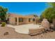 Backyard view of the house, showing covered patio and outdoor fireplace with landscaping at 4286 E Buckboard Rd, Gilbert, AZ 85297