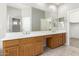 Bright bathroom featuring a double sink vanity with wood cabinets and a large mirror at 4286 E Buckboard Rd, Gilbert, AZ 85297