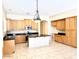 Spacious kitchen with a large island, wood cabinets, black countertops, and stainless steel appliances at 4286 E Buckboard Rd, Gilbert, AZ 85297
