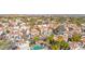 Aerial view of a neighborhood with multiple red roofed townhomes and a pool surrounded by palm trees at 5018 E Siesta Dr # 3, Phoenix, AZ 85044