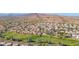 An aerial view of a community with lush green landscape and homes in front of large hills at 5018 E Siesta Dr # 3, Phoenix, AZ 85044