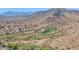 A landscape aerial of a community surrounded by desert land, a golf course, and distant mountains at 5018 E Siesta Dr # 3, Phoenix, AZ 85044