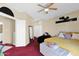 Bright bedroom featuring red carpet, a ceiling fan, a full-length mirror, and a comfortable-looking beanbag chair at 5018 E Siesta Dr # 3, Phoenix, AZ 85044