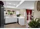 Bright kitchen featuring white cabinets, modern appliances, and a window view, seamlessly connecting to a dining area at 5018 E Siesta Dr # 3, Phoenix, AZ 85044