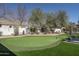 Putting green with lounge chairs, manicured landscaping, and mature desert trees at 5045 N 22Nd St, Phoenix, AZ 85016