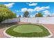 Backyard putting green and white brick wall offer outdoor activities and provide privacy at 5101 E Winchcomb Dr, Scottsdale, AZ 85254