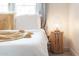 Bright bedroom features a white duvet, decorative pillows, a woven lamp, and bedside table at 5101 E Winchcomb Dr, Scottsdale, AZ 85254