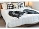 Bedroom features a wooden bed frame, white duvet, and black and white patterned pillows and blanket at 5101 E Winchcomb Dr, Scottsdale, AZ 85254
