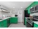 Updated kitchen featuring bold green cabinets, modern appliances, quartz countertops, and stylish decor at 5101 E Winchcomb Dr, Scottsdale, AZ 85254