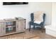 Comfortable living room seating area features a decorative chair and an entertainment center by a white brick fireplace at 5101 E Winchcomb Dr, Scottsdale, AZ 85254