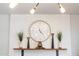 Stylish decorative brick fireplace mantel with a round clock, vases, and books adds charm to the living room at 5101 E Winchcomb Dr, Scottsdale, AZ 85254