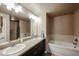 Bathroom featuring a double sink vanity with granite countertops, soaking tub, and modern fixtures at 5450 E Deer Valley Dr # 2193, Phoenix, AZ 85054