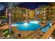 Night view of the pristine pool, showcasing palm trees, lounge chairs, and beautiful building architecture at 5450 E Deer Valley Dr # 2193, Phoenix, AZ 85054