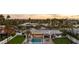 An aerial view captures this sprawling estate featuring a large pool and manicured lawn during a picturesque sunset at 6302 E Hillcrest Blvd, Scottsdale, AZ 85251