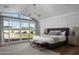 Bright bedroom featuring neutral color palette, wainscoting, and sliding glass doors to the backyard at 6302 E Hillcrest Blvd, Scottsdale, AZ 85251