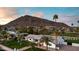 Beautiful home featuring manicured lawn and palm trees set against a mountain backdrop at sunrise or sunset at 6302 E Hillcrest Blvd, Scottsdale, AZ 85251