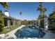 Beautiful backyard pool surrounded by lush landscaping, a pergola, and palm trees at 6531 N 81St Pl, Scottsdale, AZ 85250