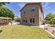 Backyard view of a large two-story home featuring grass, a patio, and outdoor seating area at 8534 W Salter Dr, Peoria, AZ 85382