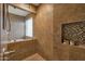 Walk-in tiled shower with glass door, mosaic accents, and window allowing natural light at 8534 W Salter Dr, Peoria, AZ 85382